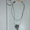 Silver-colored pendant with blue stones on a chain.