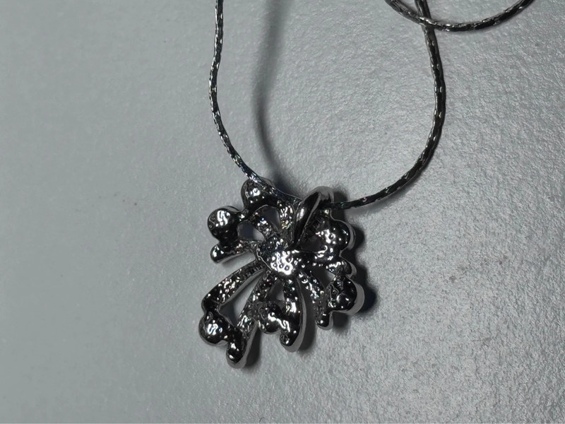 Silver-colored pendant with blue stones on a chain.