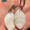 Silver earrings with a mother-of-pearl mosaic, shimmering in pink, white, and blue tones.