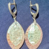 Silver earrings with a mother-of-pearl mosaic, shimmering in pink, white, and blue tones.