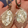 Silver earrings with a mother-of-pearl mosaic, shimmering in pink, white, and blue tones.