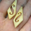 Vintage carved bone dangle earrings in a diamond shape.