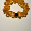 Ancient high-quality large amber bracelet with an onyx bead (for a slender wrist)