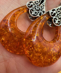 A pair of ornate sterling silver and reconstituted amber earrings