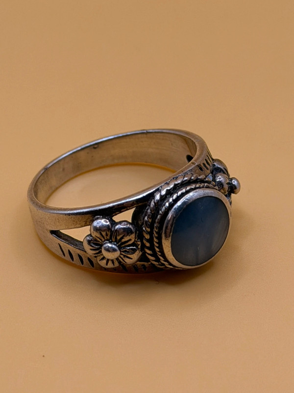 silver ring with a moonstone, adorned with floral patterns. Size R#14
