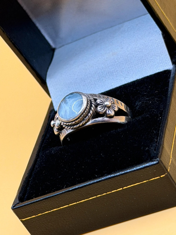 silver ring with a moonstone, adorned with floral patterns. Size R#14