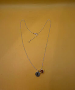 Silver-tone necklace with a pendant set with a yellow stone and an A initial