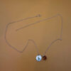 Silver-tone necklace with a pendant set with a yellow stone and an A initial.