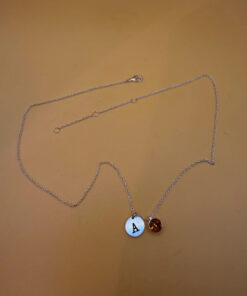 Silver-tone necklace with a pendant set with a yellow stone and an A initial