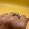 A silver ring, size M, with three large clear stones~108