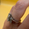 A silver ring, size M, with three large clear stones~108
