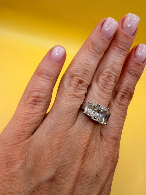 A silver ring, size M, with three large clear stones~108