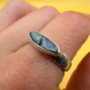 A silver ring featuring a natural opal, size Q