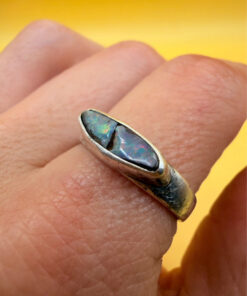 A silver ring featuring a natural opal, size Q