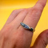 A silver ring featuring a natural opal, size Q