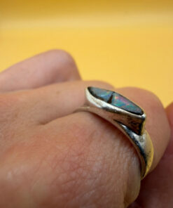 A silver ring featuring a natural opal, size Q
