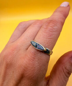 A silver ring featuring a natural opal, size Q