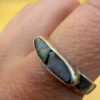 A silver ring featuring a natural opal, size Q