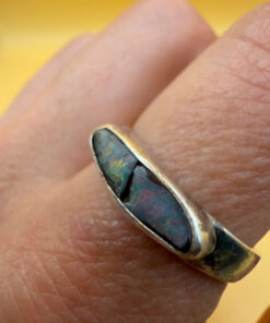 A silver ring featuring a natural opal, size Q