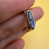 A silver ring featuring a natural opal, size Q