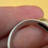 A silver ring featuring a natural opal, size Q