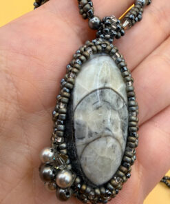 Necklace with a polished Orthoceras fossil cabochon and beads.