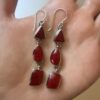 Vintage sterling silver earrings set with natural red coral cabochons.