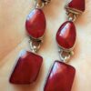 Vintage sterling silver earrings set with natural red coral cabochons.