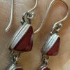 Vintage sterling silver earrings set with natural red coral cabochons.