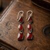Vintage sterling silver earrings set with natural red coral cabochons.